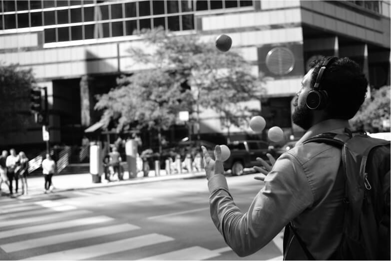 A man juggling while crossing the street. A cheesy metaphor for life's challenges